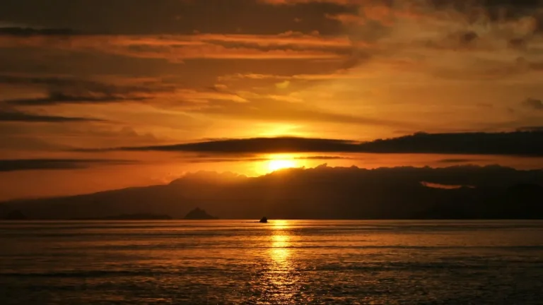 Small boat on a calm sea at sunset