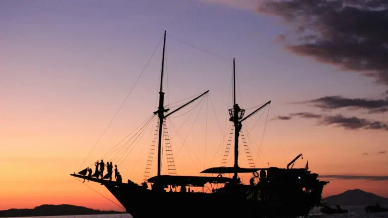 Phinisi schooner silhouetted at sunset
